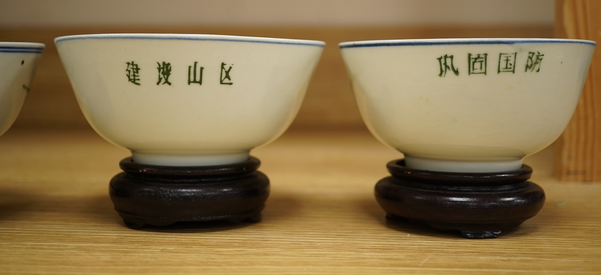 A Chinese Cultural Revolution porcelain teapot, six bowls, wood stands and an enamel tray-29.5cm diameter. (8)